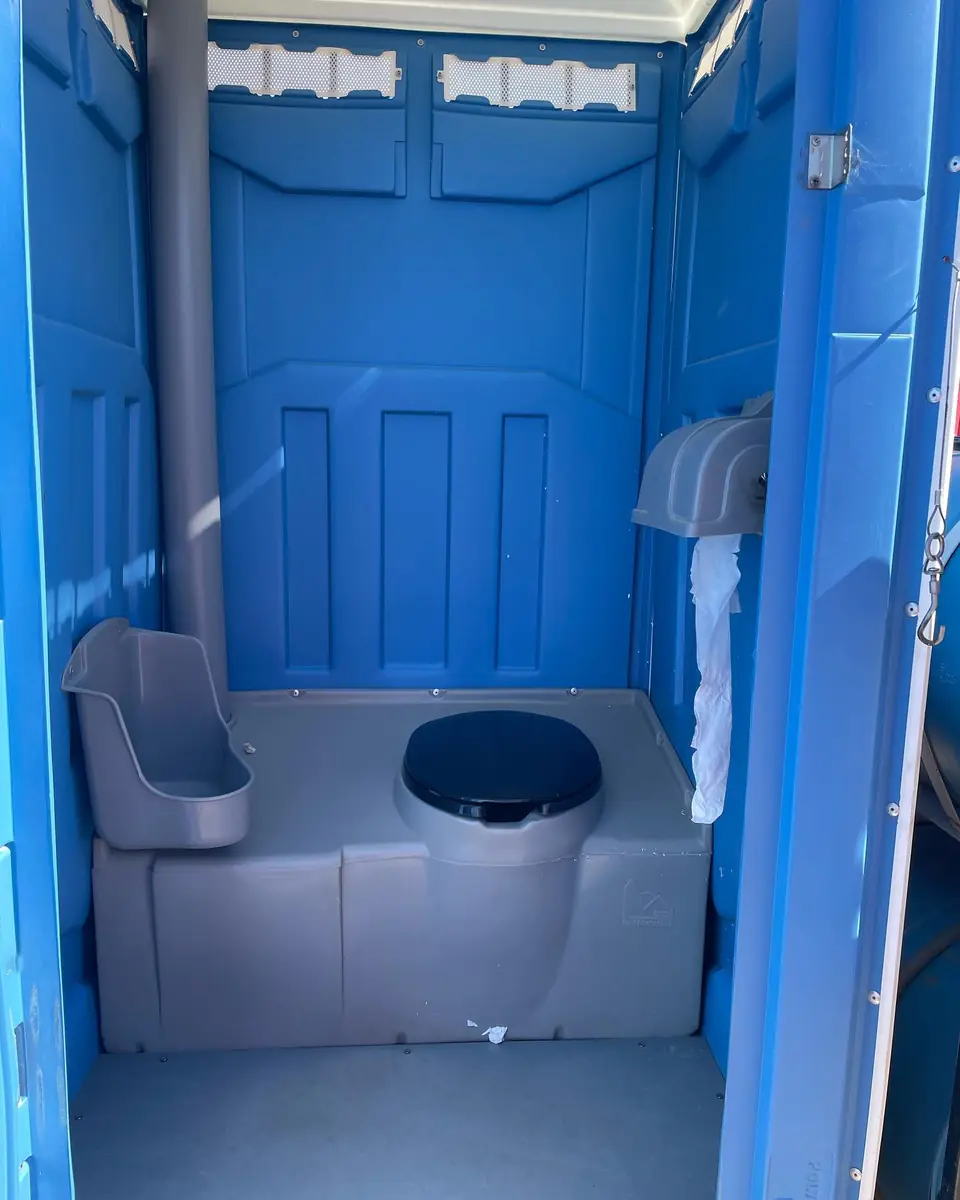 Wide view of a clean blue porta potty interior