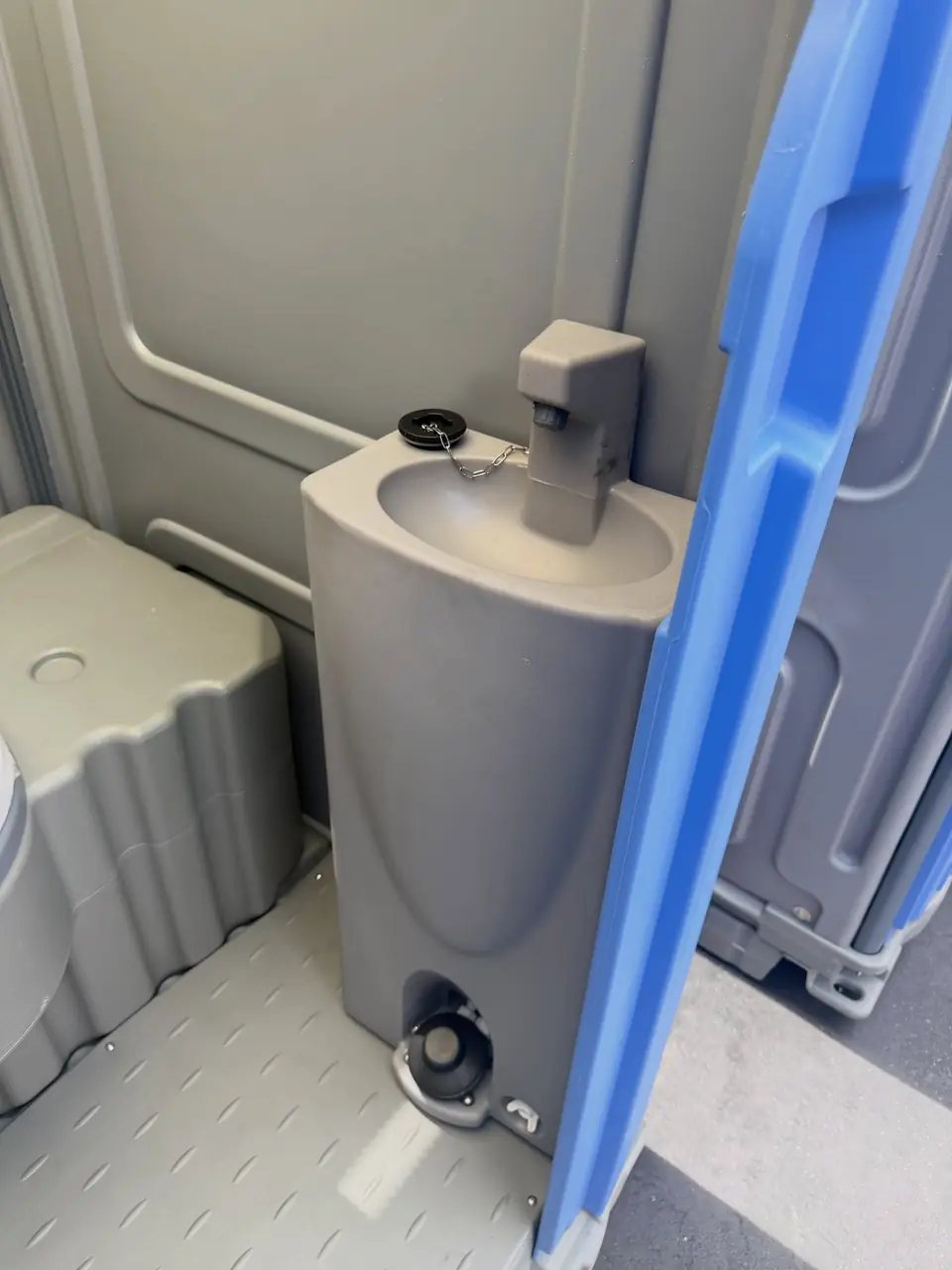Deluxe porta potty interior with foot-pump sink