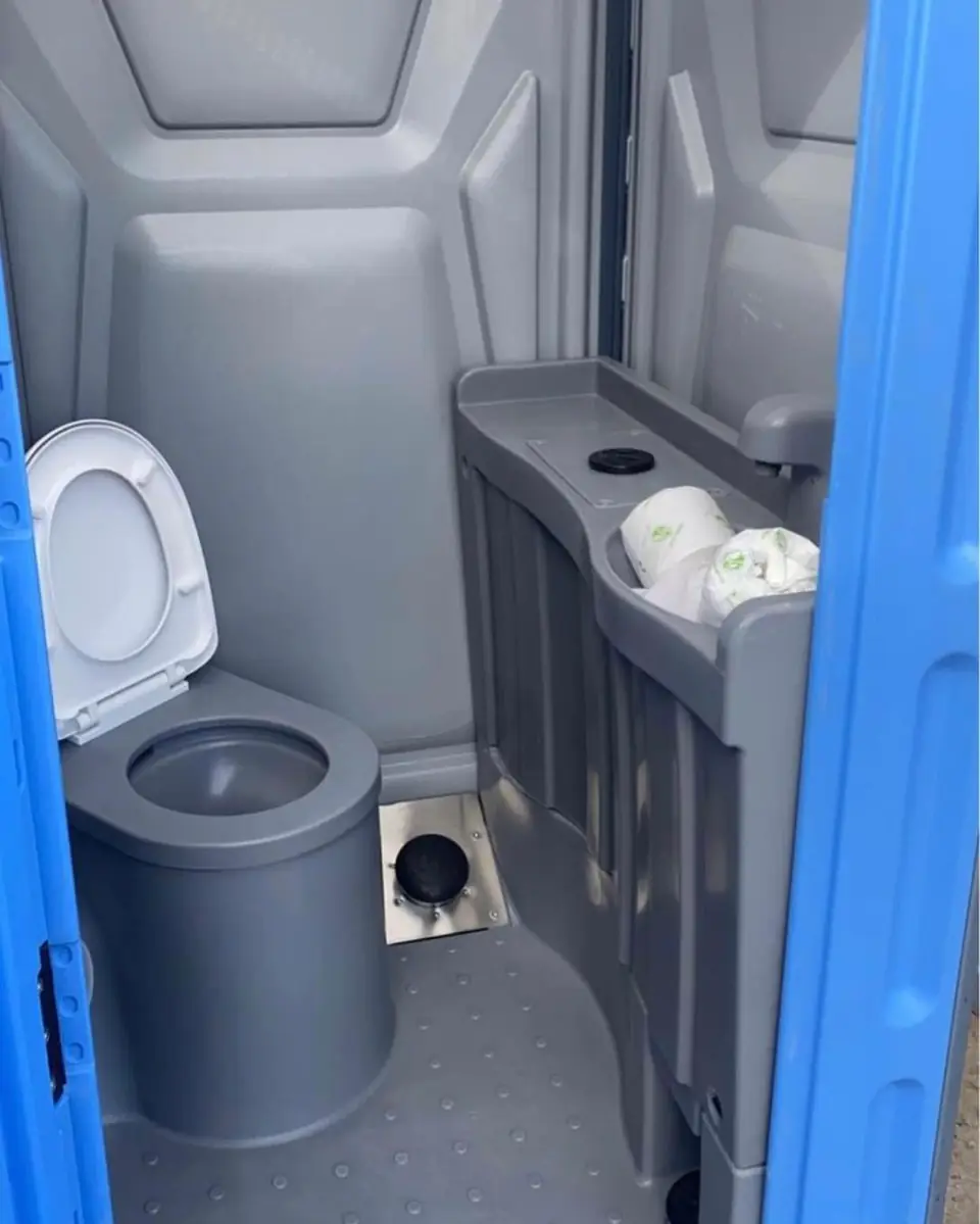 Gray porta potty interior with a small sink and soap area
